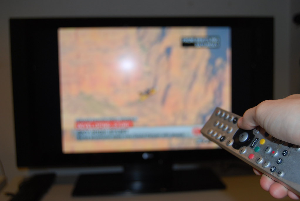 Person setting up an IPTV app on an Android box with a remote control